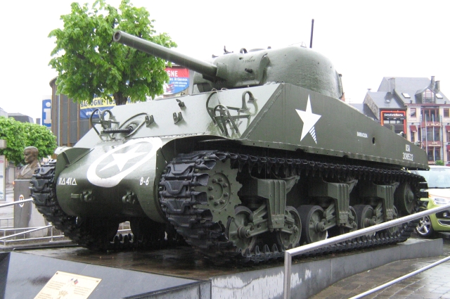 a sherman tank on a plinth in bastogne town centre
